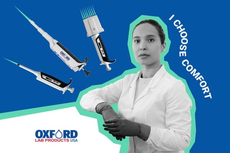 Female lab technician in a lab coat and gloves standing confidently next to Oxford Lab Products ergonomic pipettes with the slogan “I Choose Comfort”